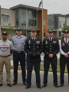 U.S. veterans standing proudly before a modern building, symbolizing new housing and education opportunities.